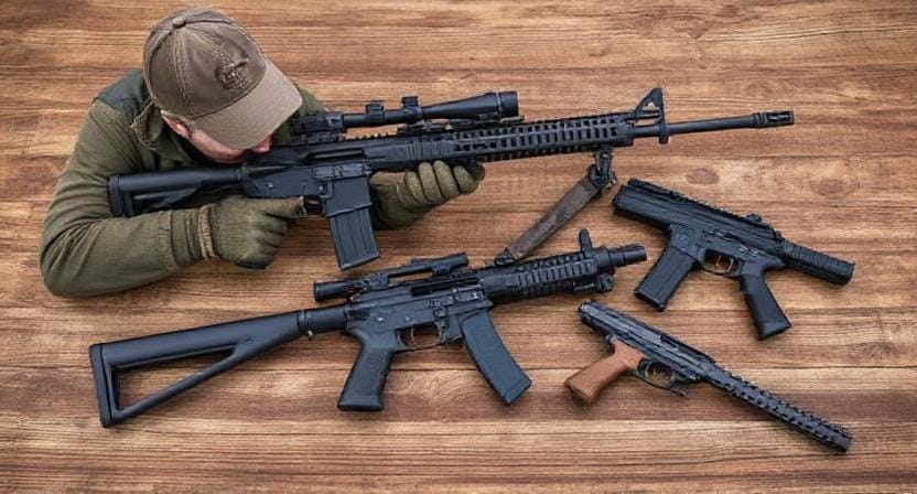 Survivalist Choosing from Different Kinds Of Guns